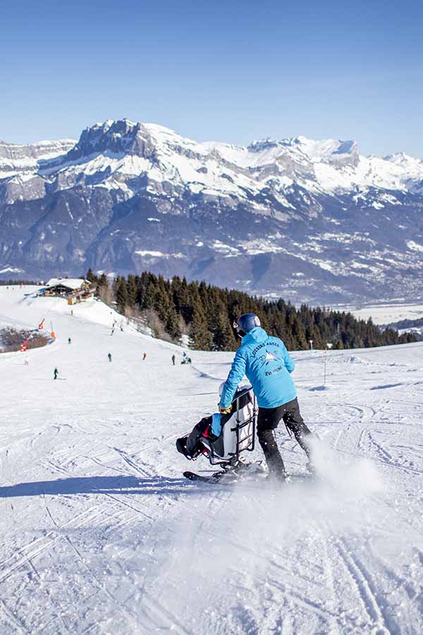 tandemski-fred-combloux une personne en tandemski avec un guide de loisirs assis evasion